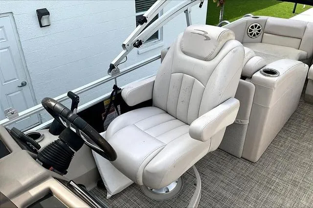 Slide: The Image of Captain's chair on 2014 Bennington 2375 GCW pontoon boat, featuring plush white upholstery. - 13