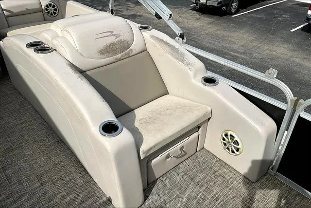 Slide: The Image of 2014 Bennington 2375 GCW boat seating area with cup holders and storage compartment. - 14