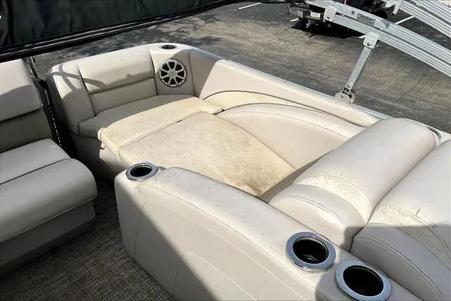 Slide: The Image of 2014 Bennington 2375 GCW boat interior with beige seating and cup holders. - 16