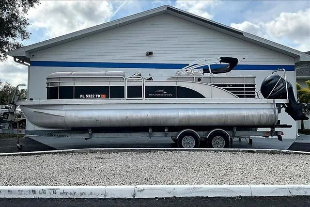Slide: The Image of 2014 Bennington 2375 GCW pontoon boat on trailer, parked outside a building. - 2