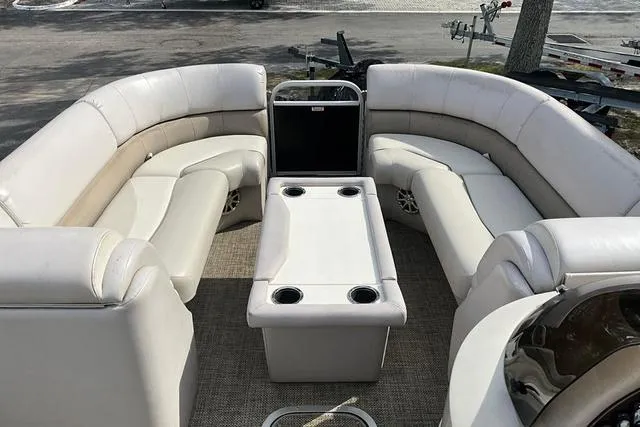 Slide: The Image of 2014 Bennington 2375 GCW pontoon boat interior with plush seating and central table. - 20