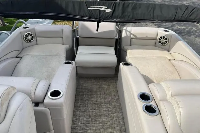 Slide: The Image of 2014 Bennington 2375 GCW boat interior with beige seating and cup holders. - 22