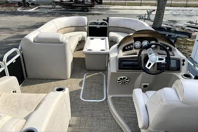 Slide: The Image of 2014 Bennington 2375 GCW pontoon boat interior with beige seating and steering console. - 7