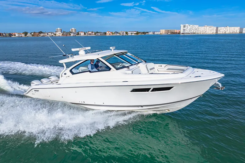 Slide: The Image of 2021 Pursuit DC 365 Dual Console boat cruising on open water. - 10