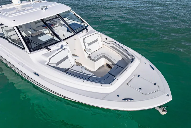 Slide: The Image of 2021 Pursuit DC 365 Dual Console boat on clear water, showcasing sleek design and spacious seating. - 11