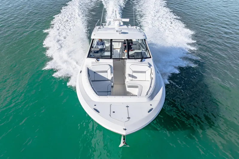 Slide: The Image of 2021 Pursuit DC 365 Dual Console boat cruising on clear turquoise water. - 13
