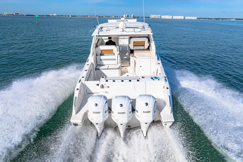 Slide: The Image of 2021 Pursuit DC 365 Dual Console boat cruising on open water. - 16