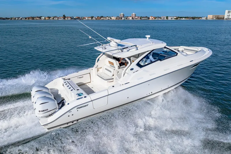 Slide: The Image of 2021 Pursuit DC 365 Dual Console boat cruising on open water, showcasing sleek design and powerful engines. - 17