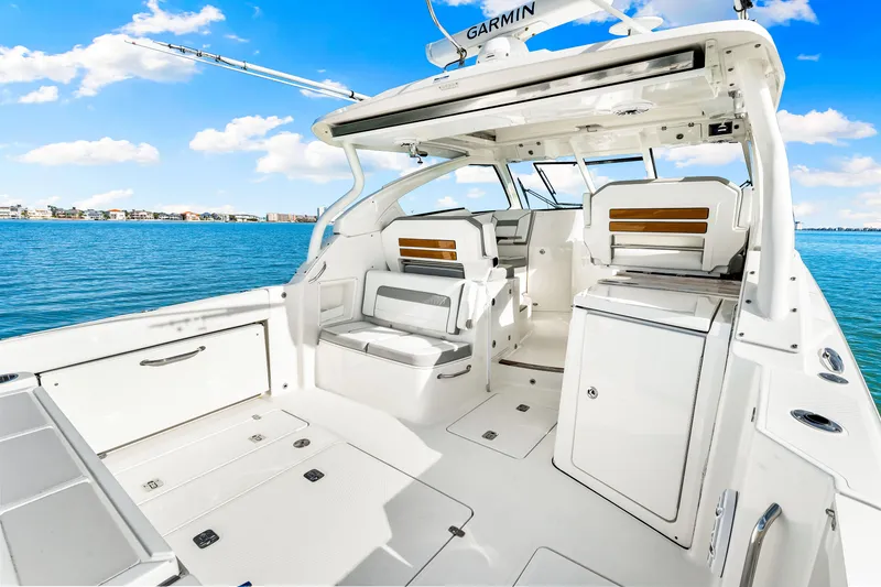 Slide: The Image of 2021 Pursuit DC 365 Dual Console boat interior with seating, ocean view, and clear sky. - 20