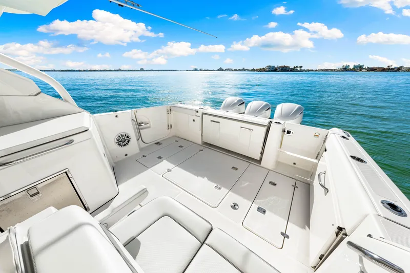 Slide: The Image of 2021 Pursuit DC 365 Dual Console boat on serene blue water. - 22