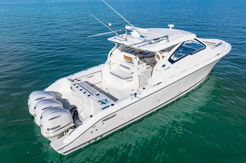 Slide: The Image of 2021 Pursuit DC 365 Dual Console boat on clear blue water. - 3
