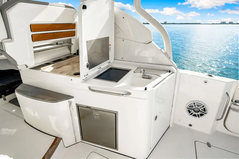 Slide: The Image of 2021 Pursuit DC 365 Dual Console boat interior with kitchenette and ocean view. - 30