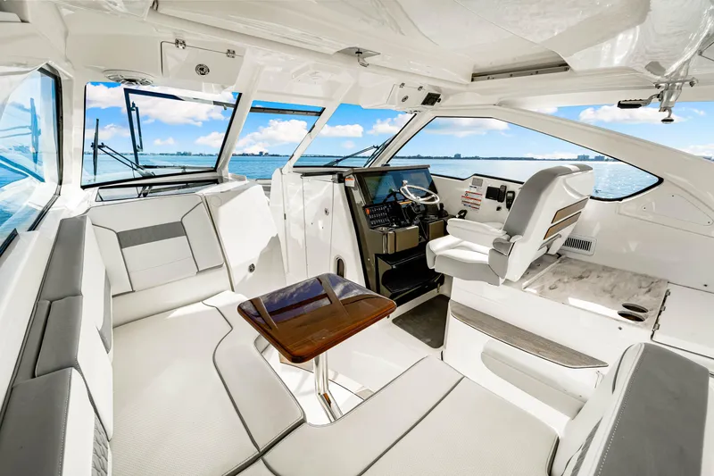 Slide: The Image of 2021 Pursuit DC 365 Dual Console interior with seating, helm, and ocean view. - 33