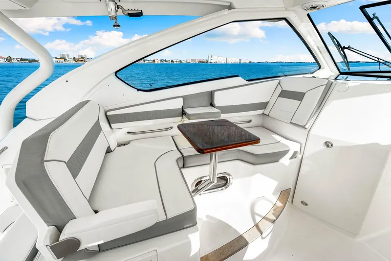 Slide: The Image of 2021 Pursuit DC 365 Dual Console interior with seating and table, overlooking blue ocean. - 34