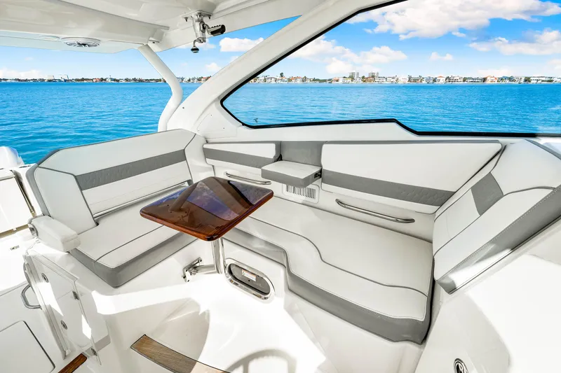 Slide: The Image of 2021 Pursuit DC 365 Dual Console interior with seating and table, overlooking blue water. - 35