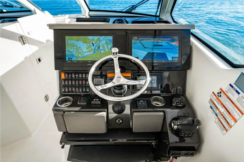Slide: The Image of 2021 Pursuit DC 365 Dual Console helm with navigation screens and steering wheel. - 37