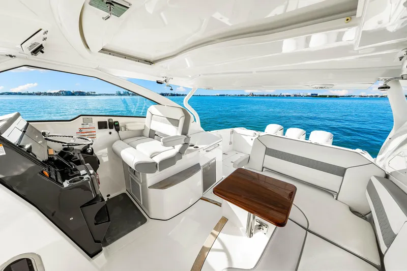 Slide: The Image of 2021 Pursuit DC 365 Dual Console boat interior with seating and helm, overlooking blue water. - 38