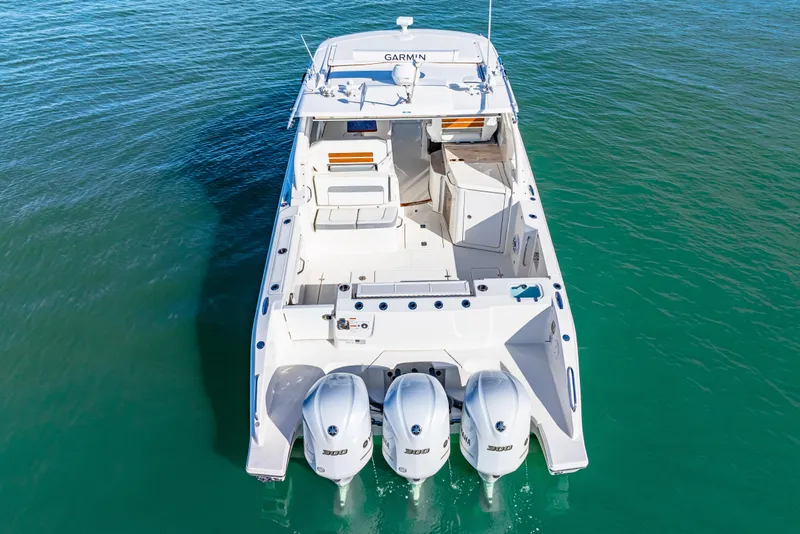 Slide: The Image of 2021 Pursuit DC 365 Dual Console boat with triple engines on clear water. - 4
