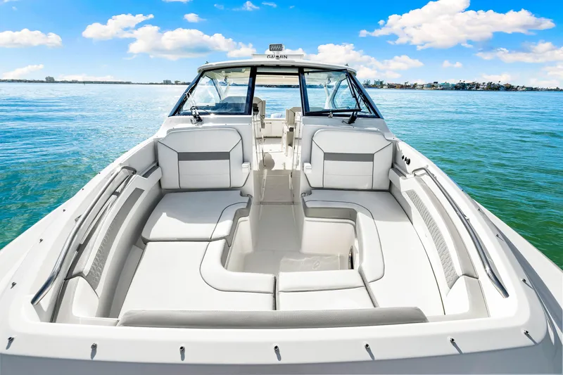 Slide: The Image of 2021 Pursuit DC 365 Dual Console boat on calm water, featuring spacious seating. - 43