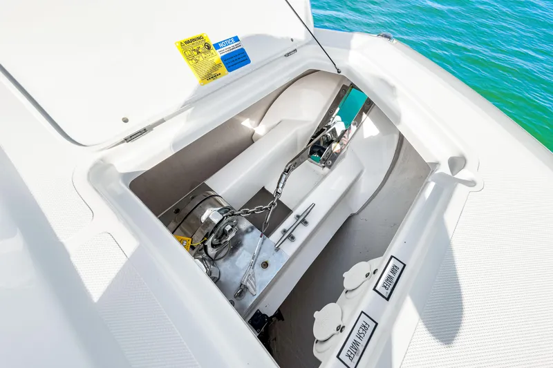 Slide: The Image of 2021 Pursuit DC 365 Dual Console anchor compartment with chain and winch. - 44
