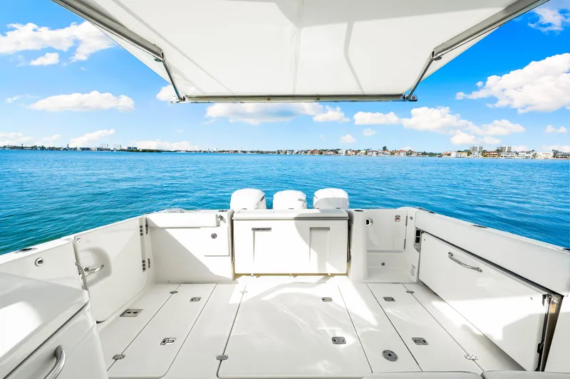 Slide: The Image of 2021 Pursuit DC 365 Dual Console boat with spacious deck overlooking serene blue waters. - 45