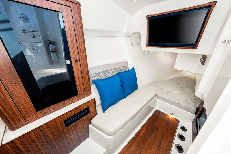 Slide: The Image of 2021 Pursuit DC 365 Dual Console cabin with seating, TV, and wood accents. - 46