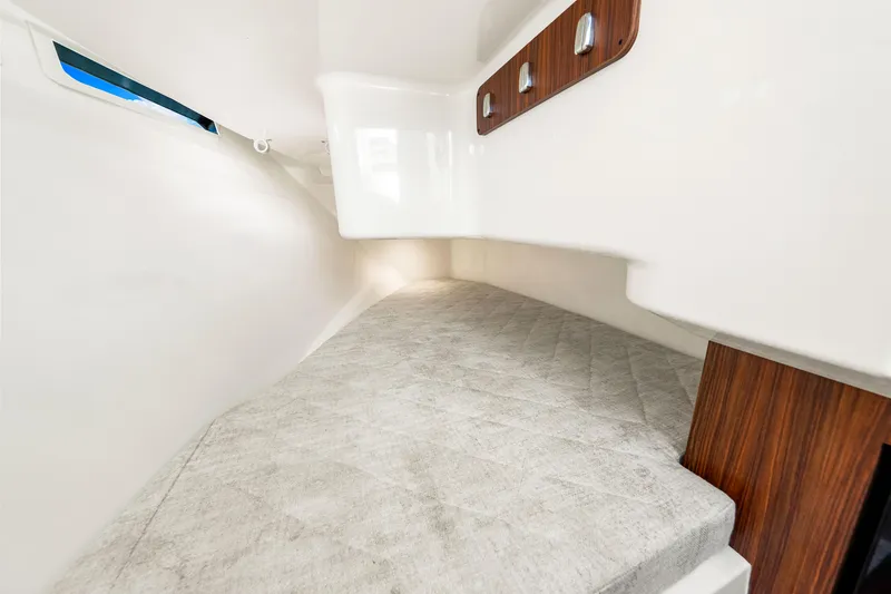 Slide: The Image of 2021 Pursuit DC 365 Dual Console cabin interior with cushioned seating and wooden accents. - 48