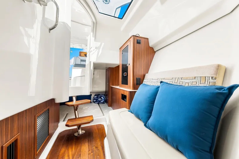Slide: The Image of 2021 Pursuit DC 365 Dual Console interior with wood accents and blue cushions. - 49