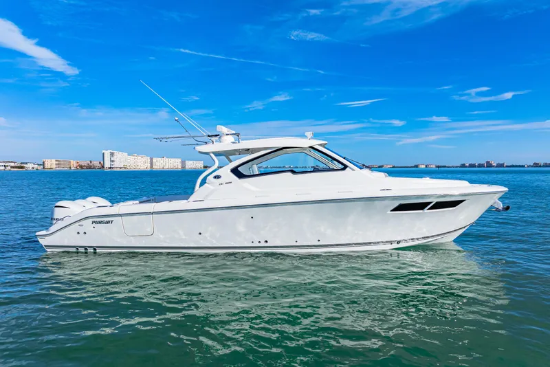 Slide: The Image of 2021 Pursuit DC 365 Dual Console boat on clear blue water. - 5