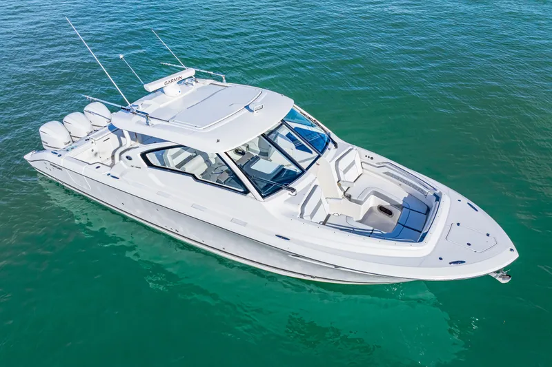 Slide: The Image of 2021 Pursuit DC 365 Dual Console boat on clear blue water. - 6