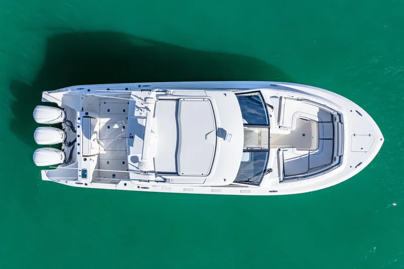Slide: The Image of 2021 Pursuit DC 365 Dual Console boat on clear turquoise water, aerial view. - 9