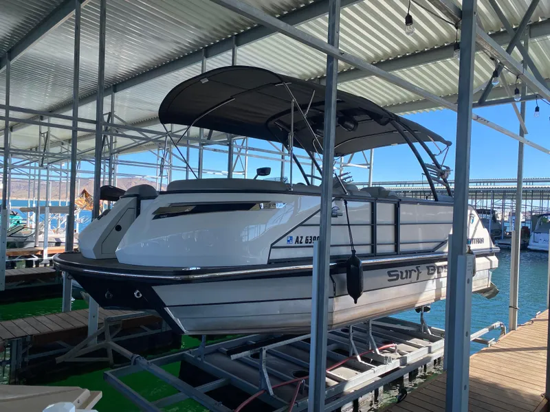 Slide: The Image of 2022 Montara 25 SURF BOSS 2.0 boat docked under a covered marina. - 1