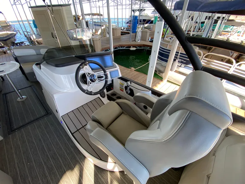 Slide: The Image of 2022 Montara 25 SURF BOSS 2.0 boat interior with steering wheel and seating. - 7