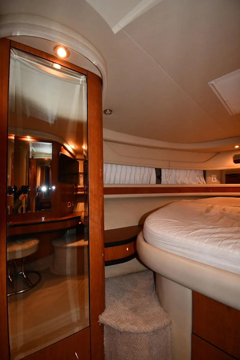 Slide: The Image of Interior of 2000 Sea Ray 460 Sundancer yacht, featuring a cozy bedroom with elegant wood finishes. - 29