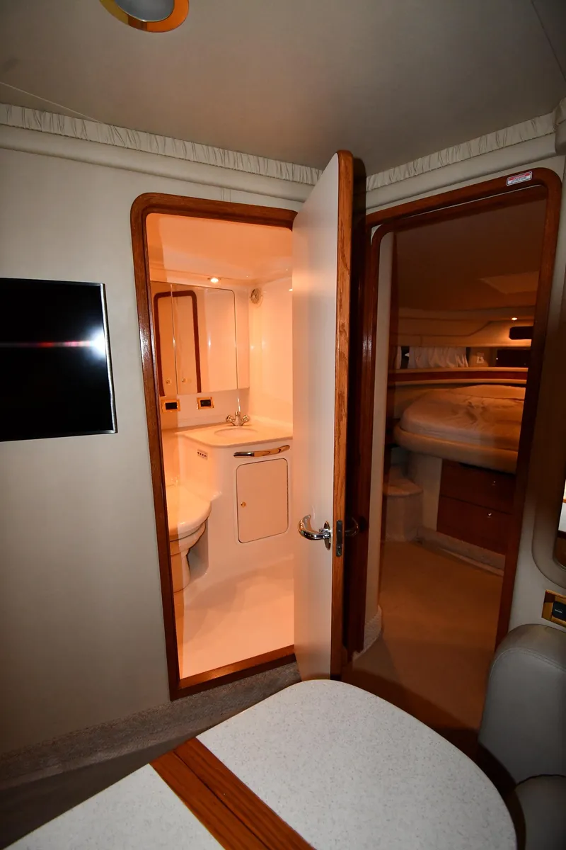 Slide: The Image of Interior of 2000 Sea Ray 460 Sundancer yacht, featuring bathroom and cozy cabin. - 33