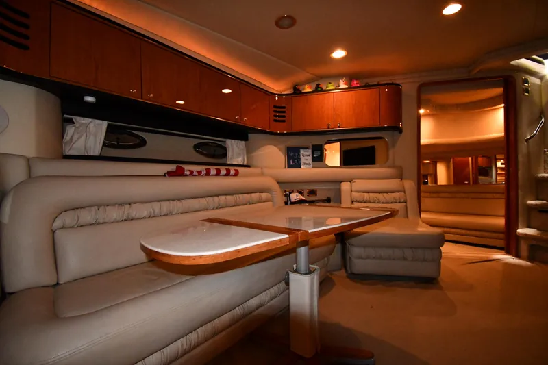Slide: The Image of Interior of 2000 Sea Ray 460 Sundancer yacht with plush seating and wooden cabinetry. - 43
