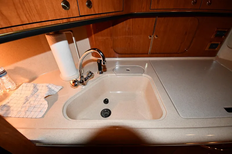 Slide: The Image of Kitchen sink area in 2000 Sea Ray 460 Sundancer yacht, featuring wooden cabinetry. - 45