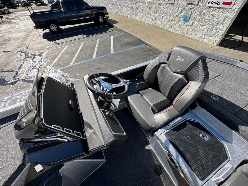 Slide: The Image of 2025 Ranger Z520 boat cockpit with steering wheel and seat, parked in a lot. - 17