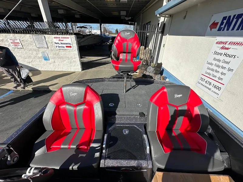Slide: The Image of 2025 Ranger Z521 boat with red and gray seating, parked in a lot. - 16