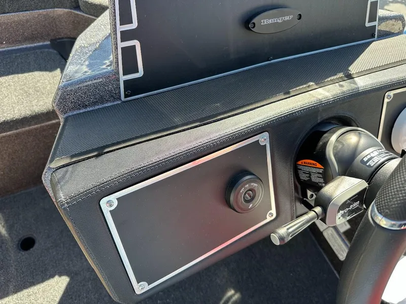 Slide: The Image of 2025 Ranger Z521 boat storage compartment with various items, including a Noco Boost Plus. - 20