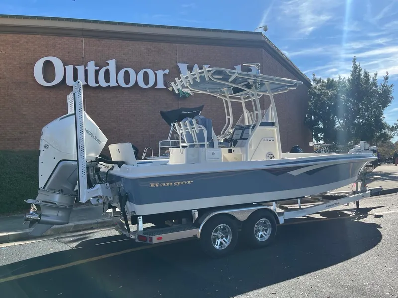 Slide: The Image of 2025 Ranger 2360 Bay boat on trailer outside a store. - 2