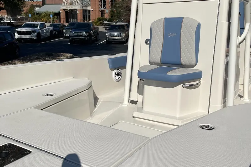 Slide: The Image of 2025 Ranger 2360 Bay boat interior with blue and gray seating in a parking lot. - 4