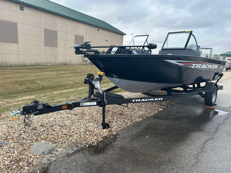 Slide: The Image of 2025 Tracker Pro Guide V-175 Combo boat on trailer, parked outdoors. - 2
