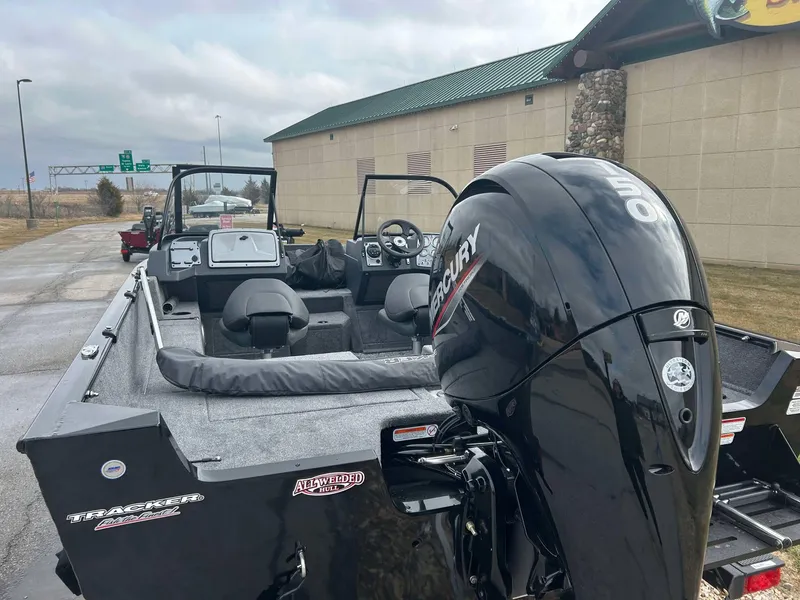 Slide: The Image of 2025 Tracker Pro Guide V-175 Combo boat with Mercury engine, parked outdoors. - 4