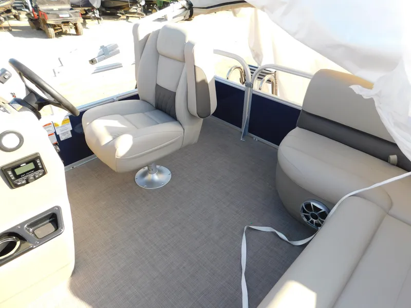 Slide: The Image of 2025 Sun Tracker Bass Buggy 16 XL Select interior with beige seating and steering console. - 16