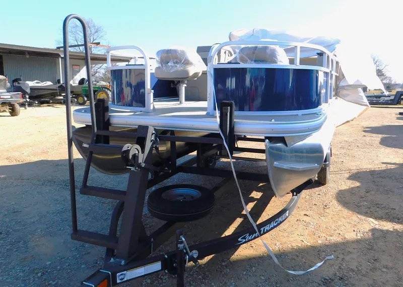 Slide: The Image of 2025 Sun Tracker Bass Buggy 16 XL Select pontoon boat on trailer. - 2