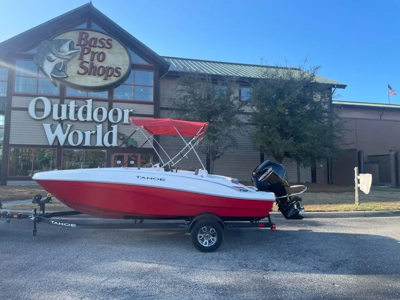 Slide: The Image of 2025 Tahoe T18 boat with red canopy outside Bass Pro Shops Outdoor World. - 1