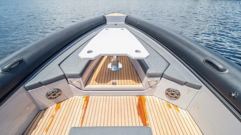 Slide: The Image of Skipper 38 NC 2025 boat deck with seating and table on calm water. - 18