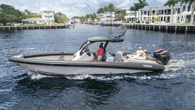 Slide: The Image of 2025 Skipper 38 NC boat cruising on a scenic waterway with luxury homes in the background. - 22