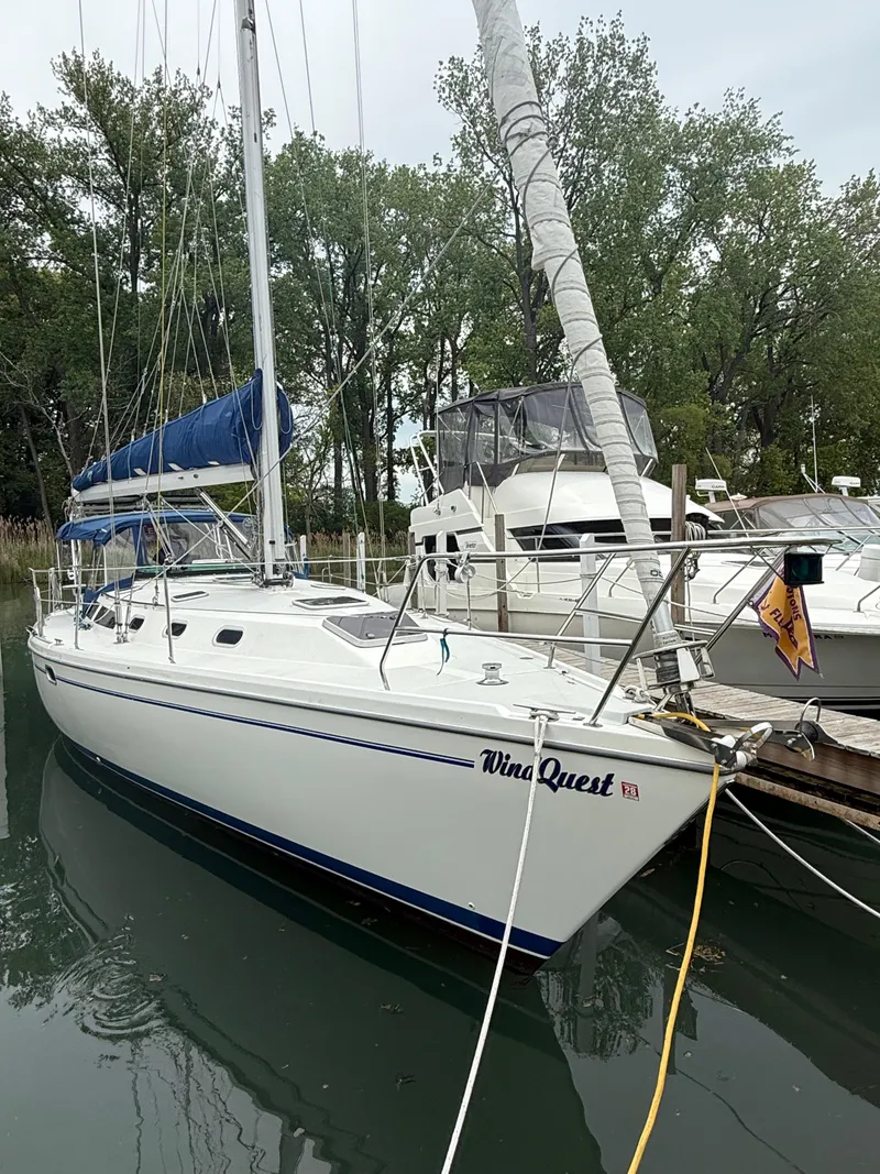 Slide: The Image of 2001 Catalina 42 MkII sailboat docked in a marina, surrounded by trees. - 1